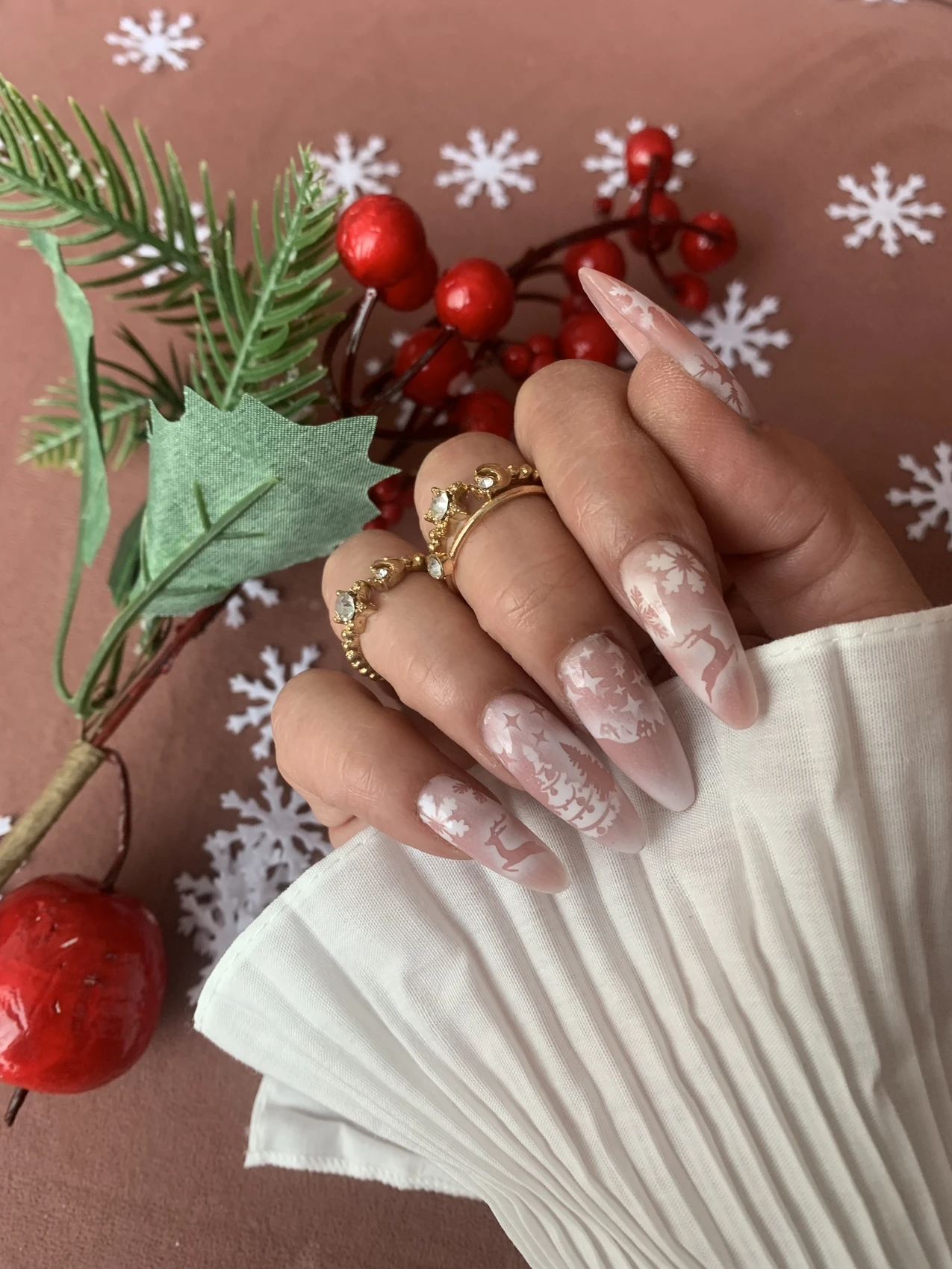 Manicura nude con degradados blancos, copos, estrellas y motivos navideños de aerografía