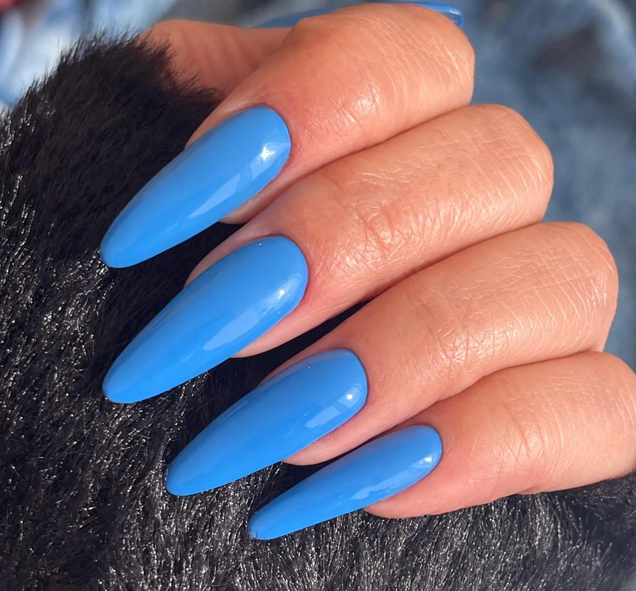 Extensión de uñas azules de forma almendrada