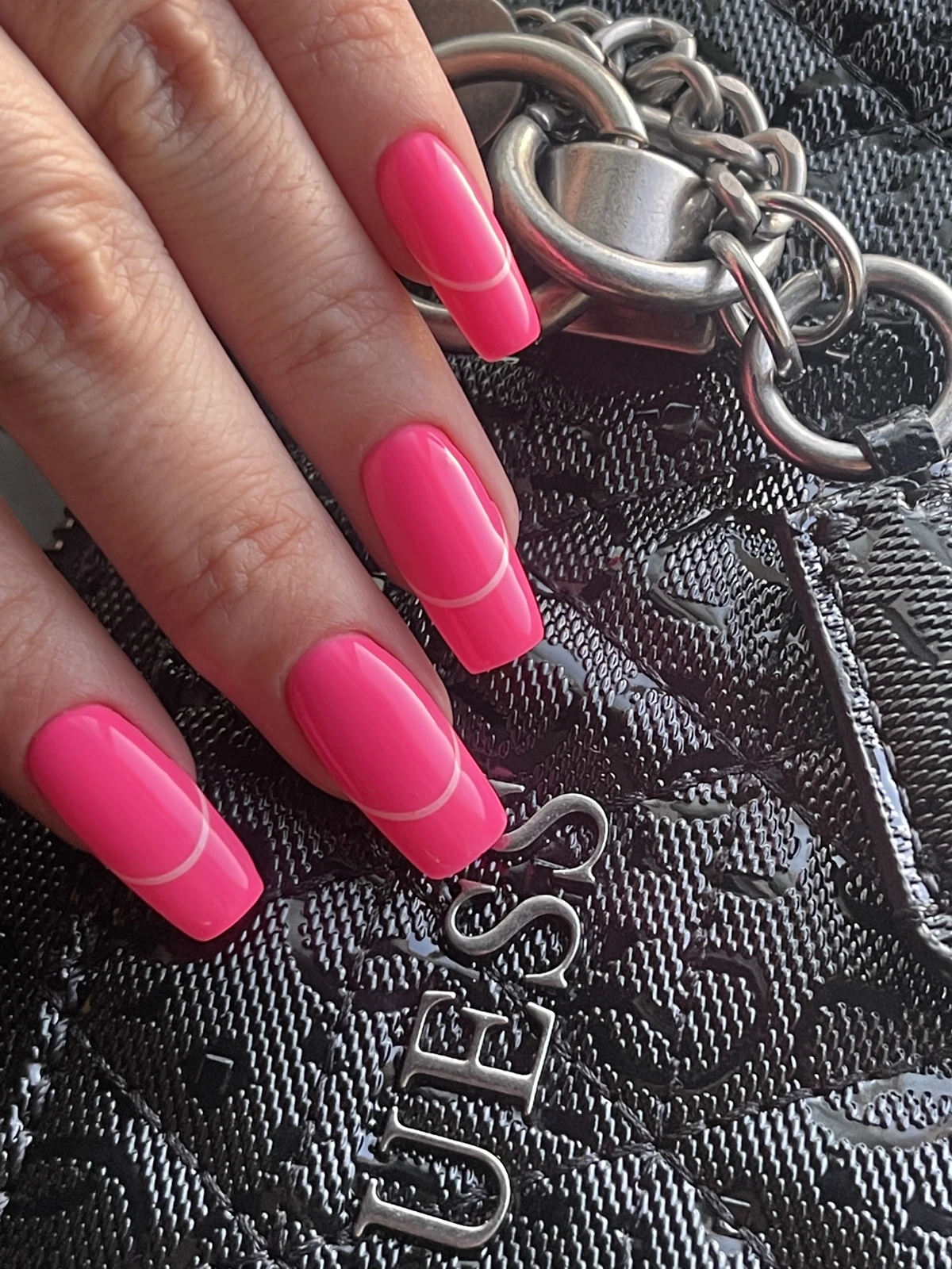 Detalle de la extensión rosa sobre bolso negro