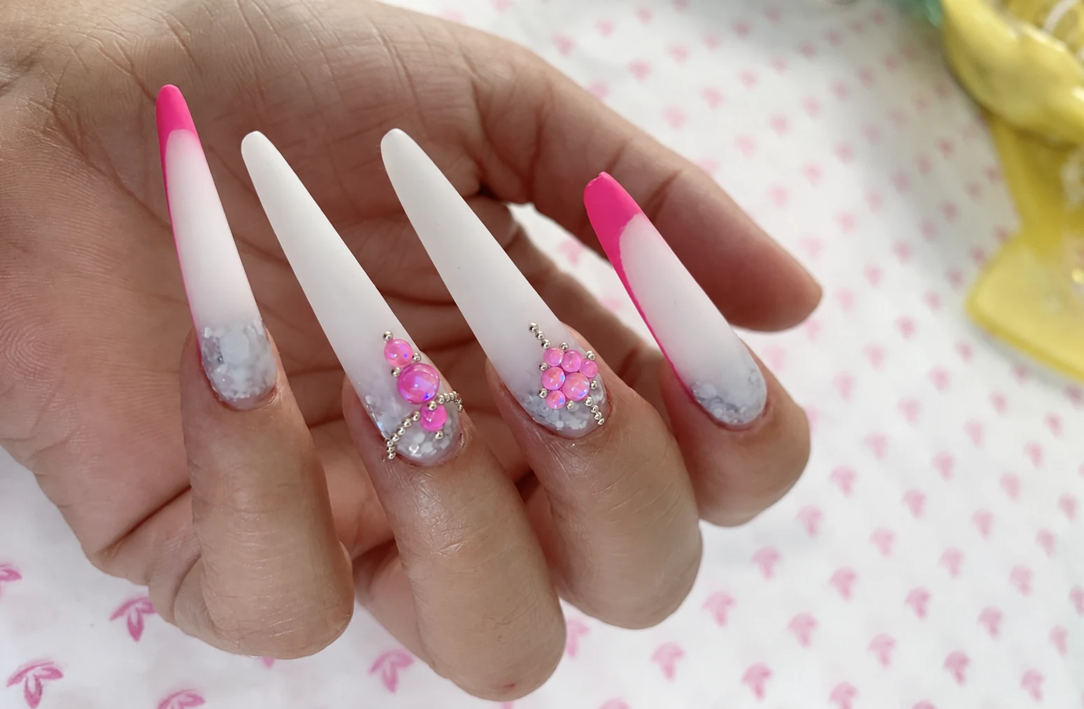 Estructura Lacoste: uñas largas blancas y rosas con pedrería