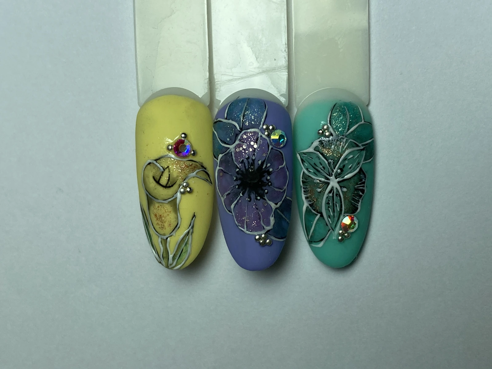 Flores realizadas por alumnas sobre fondos amarillo, violeta y turquesa