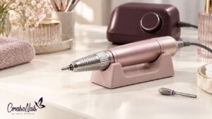 Pieza de mano y torno de manicura en una mesa rosa