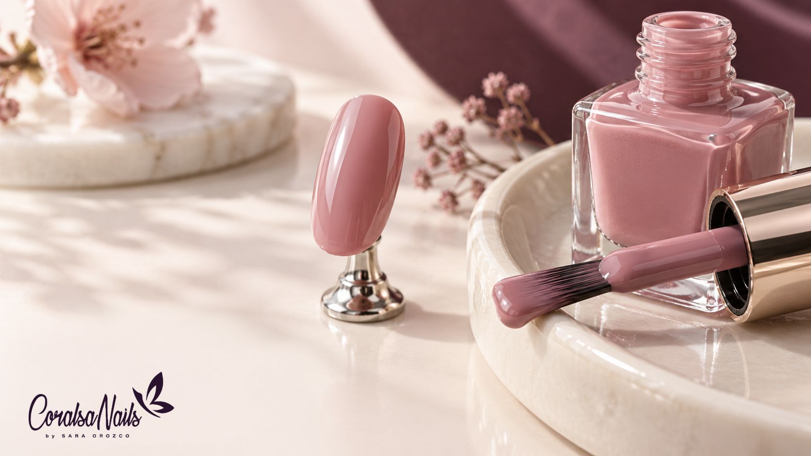 Pincel con esmalte rosa junto a un tip de práctica