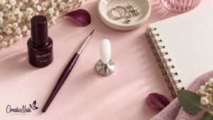 Esmalte semipermanente en bote opaco color ciruela sobre una mesa de manicura